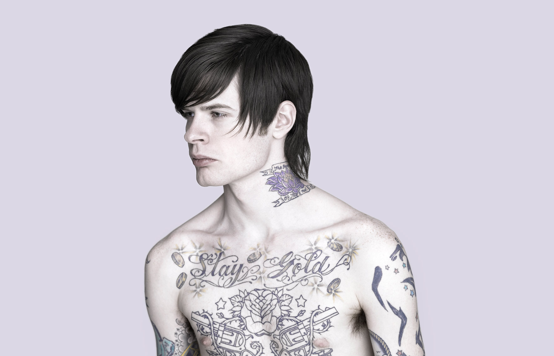 Studio portrait of a young man with tattoos