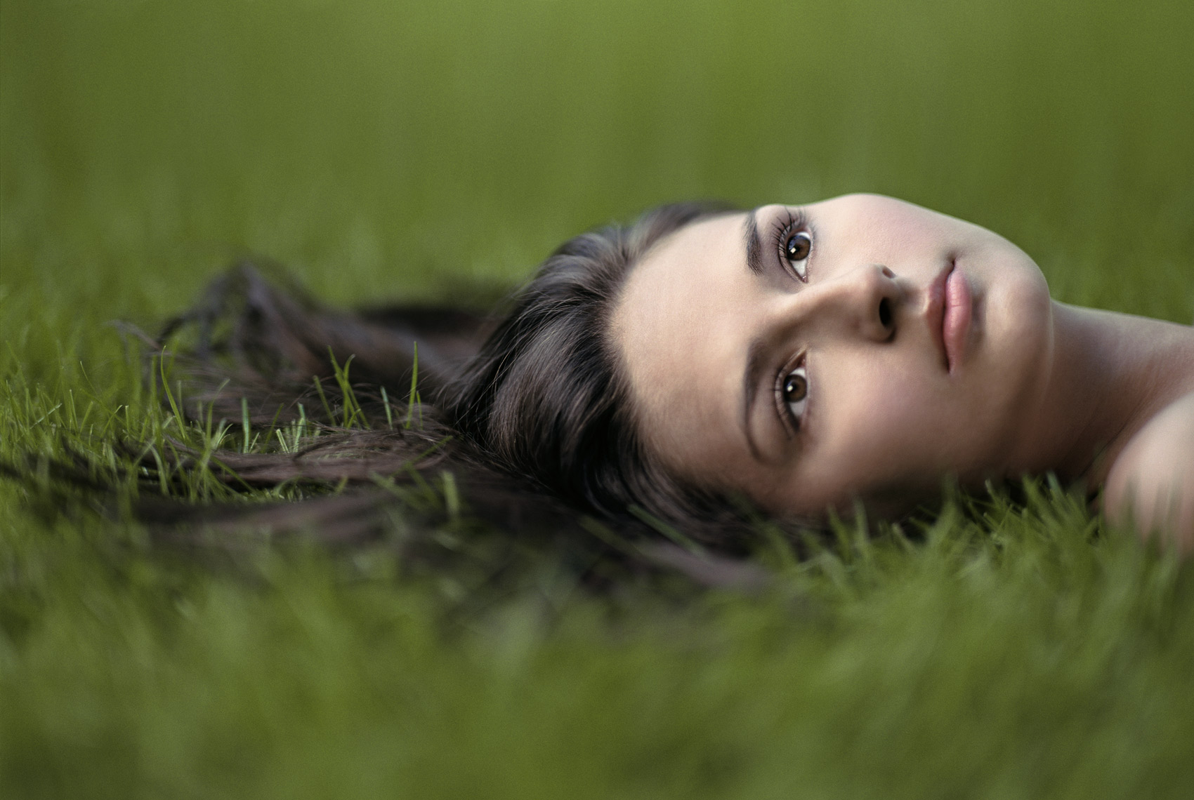 Location portrait of young woman lying in the grass