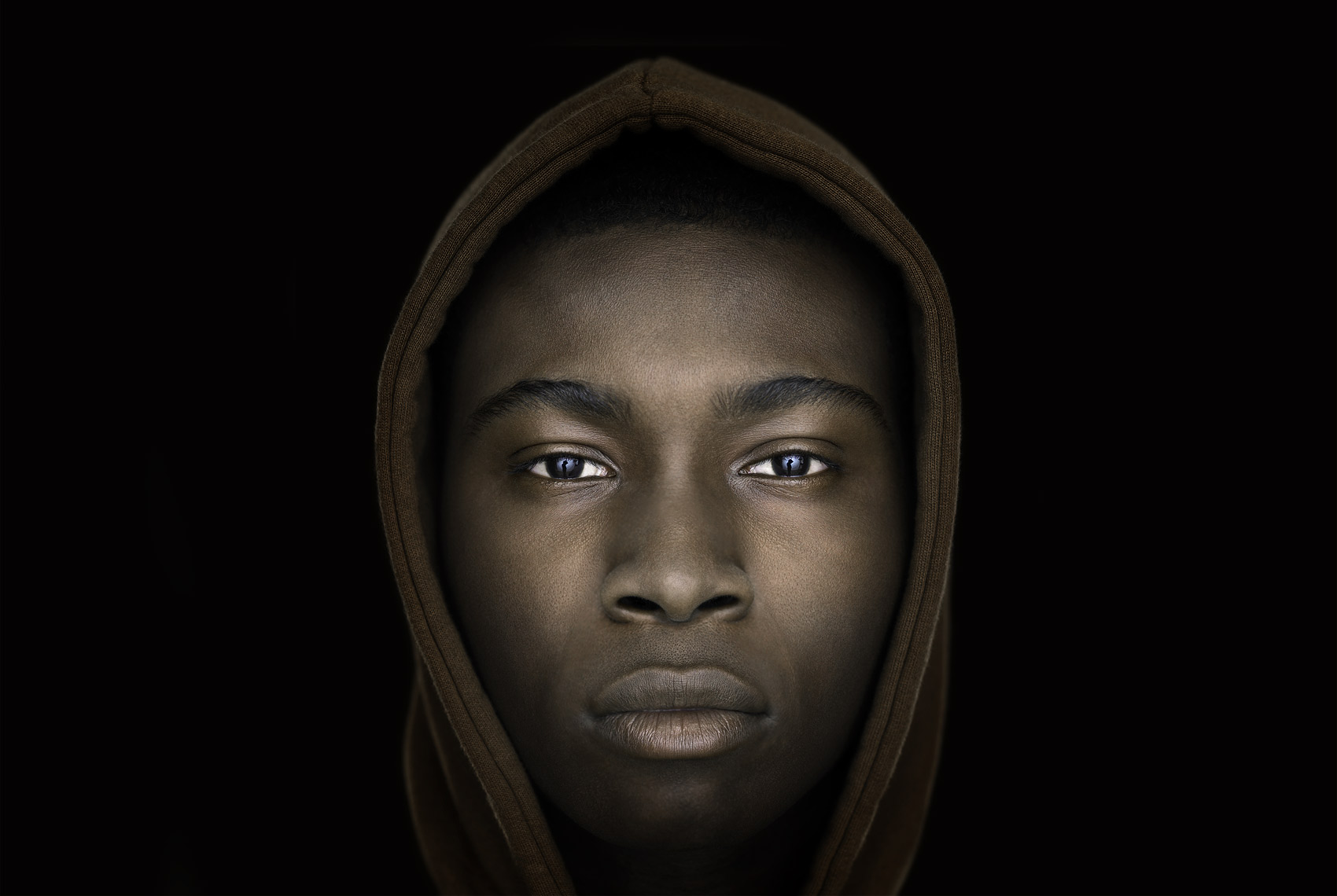 Studio portrait of a young African American man with hooded sweatshirt