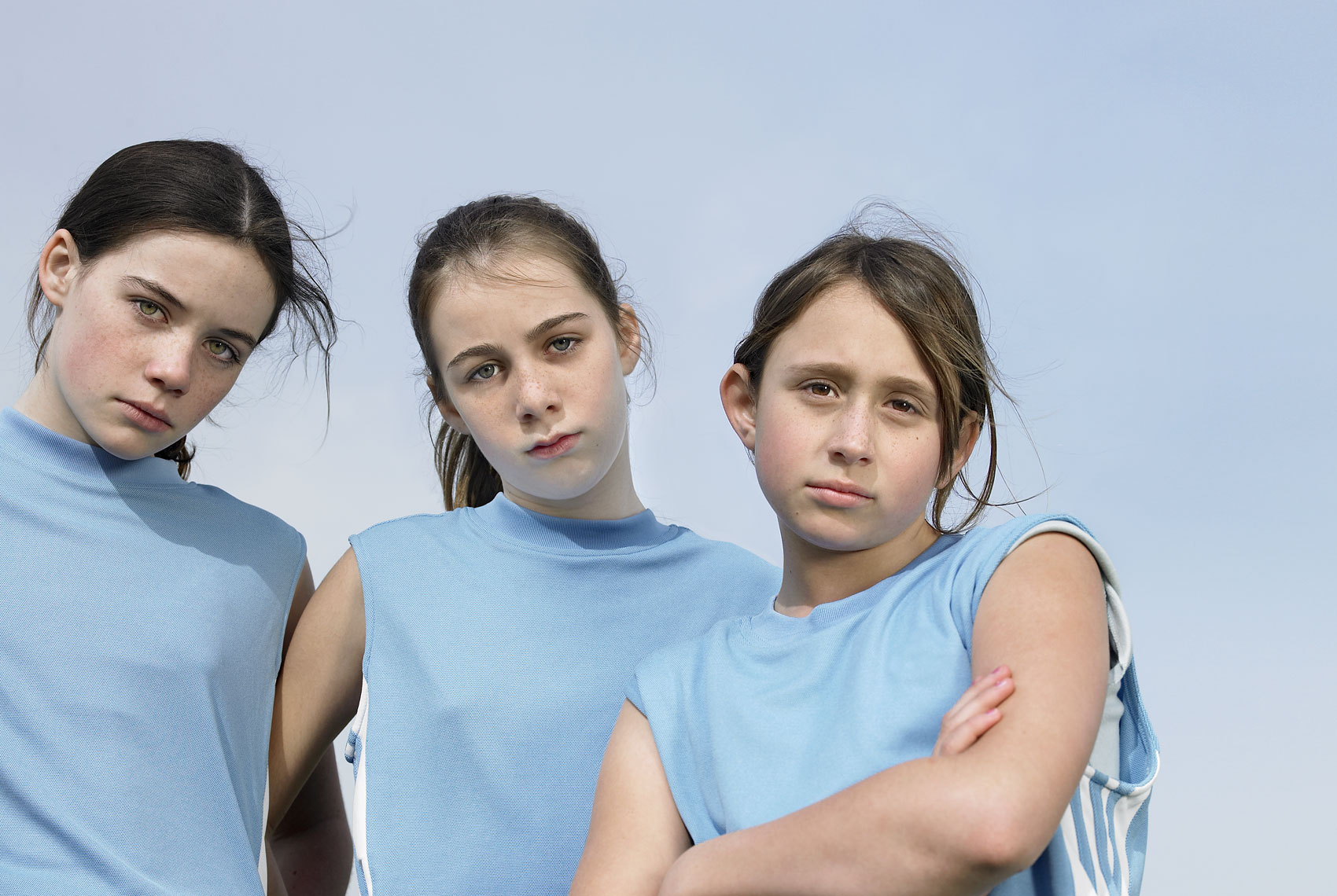 Portrait of three young girls in soccer uniforms